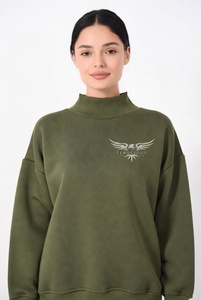 Hermosa mujer con una sudadera de cuello alto en un vibrante color rosa intenso, con delicado ribete de encaje y un audazco bordado de águila negra en el pecho. - Product Image 4