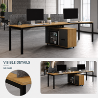 Poste de travail de bureau moderne pour deux personnes avec dessus en imitation bois, panneaux de séparation gris, cadres noirs et armoire de rangement latérale