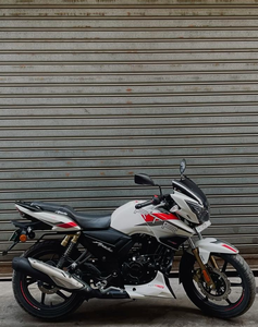 Motocyclette TVS "APACHE RTR 180" avec des touches sportives rouge, noir, argent et bleu vif, style Scrambler. - Product Image 1
