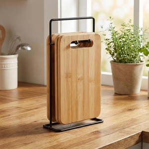 Ensemble de planches à découper en bois, 3 tailles différentes, soigneusement disposées sur un support de rangement élégant en métal noir mat, pour couper les légumes. - Product Image 1