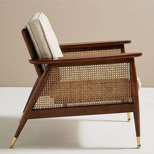 Sturdy single accent <b>chair</b> featuring woven rattan panels, a dark wood frame, and cream-colored tufted <b>cushions</b>. - Product Image 2
