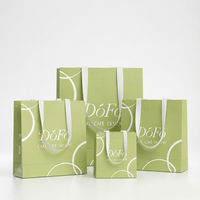Sac cadeau en papier vert minimaliste avec motifs incurvés blancs et logo de marque pour l'emballage de gâteaux, de cafés, de desserts et de plats à emporter