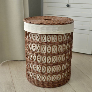 Cylindrical brown <b>wicker</b> <b>laundry</b> <b>basket</b> featuring an open lattice pattern, a removable fabric liner, and a flat woven lid, - Product Image 1