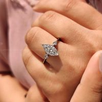 Magnifique bague de fiançailles à trois pierres de forme marquise avec une tige à bord coupé et des griffes de fixation sûres