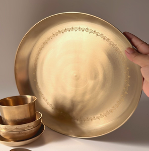 Minimalist golden bronze Kansa dinnerware set featuring delicate printed <b>border</b> motifs on the thali and bowls. - Product Image 1