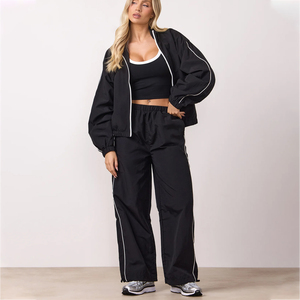 Chaqueta cortavientos negra personalizada al por mayor con logo, para mujer, con cremallera completa, cuello tipo embudo y ribetes en contraste, tela con ligeras arrugas. - Product Image 6