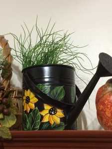 Regadera de metal negra con pintura de flores amarillas para uso en jardinería - Product Image 1