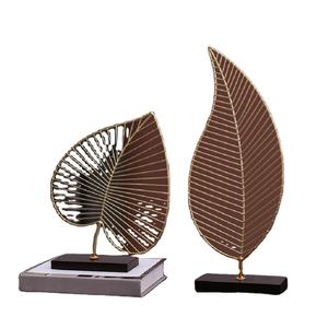 Paire de feuilles dorées contemporaines en fil métallique sur bases noires élégantes pour une touche urbaine chic. Disponible à prix de gros. - Product Image 1