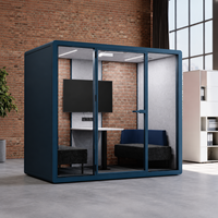 Cabine de réunion de bureau moderne bleue avec façade en verre, sièges rembourrés et table de collaboration compacte