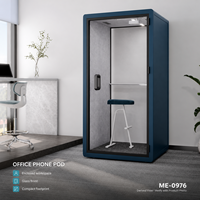 Cabine téléphonique de bureau moderne et compacte bleue avec porte en verre, étagère intérieure, tabouret blanc et espace de travail privé