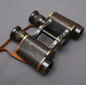 Antique brass field binoculars with textured <b>black</b> leather grip and leather strap, available at wholesale prices. - Product Image 1