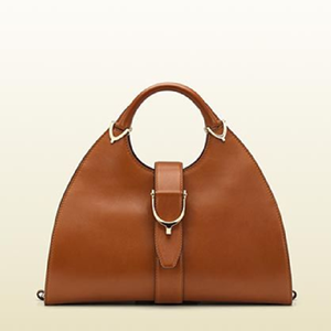 Classic tan leather <b>tote</b> <b>with</b> a circular handle and gold stirrup hardware. Polished look available at wholesale prices. - Product Image 1
