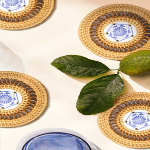 Handcrafted round rattan coasters with porcelain blue floral center inlay <b>for</b> drink <b>tables</b>, available at wholesale prices. - Product Image 1