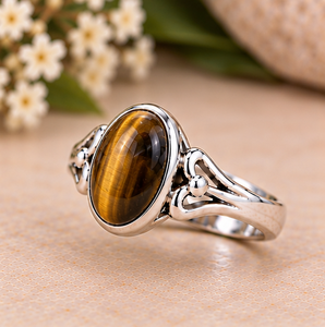 Bague élégante en argent avec pierre œil de tigre ovale, surface de pierre précieuse brillante aux couleurs marron miel chaud et détails latéraux sculptés avec raffinement. - Product Image 3
