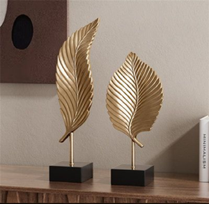 Elegante conjunto de hojas doradas curvadas en forma de pluma sobre modernos bloques rectangulares negros para escritorios. Disponible a precios de mayorista. - Product Image 1