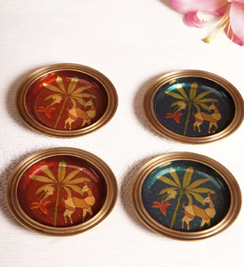 Ensemble de quatre sous-verres ronds en laiton, ornés d'un motif de cerfs traditionnel peint à la main sous des palmiers, disponibles à prix de gros. - Product Image 1