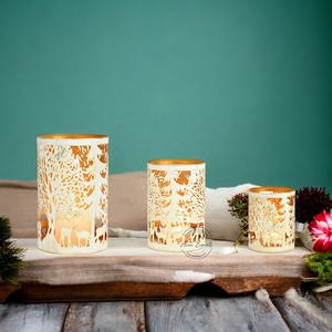 Porte-bougies artisanaux en fer et bois, motif forestier ajouré, intérieur doré chaud, offrant une décoration de Noël élégante et ambiance chaleureuse - Product Image 1