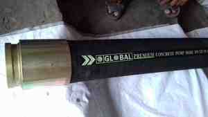 Interior de almacén industrial con manguera de bomba de hormigón en el suelo que muestra la logística de almacenamiento de equipos de construcción - Product Image 2