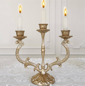 Majestic three-arm vintage brass <b>candelabra</b> with intricate scrolling flourishes available at wholesale price. - Product Image 1