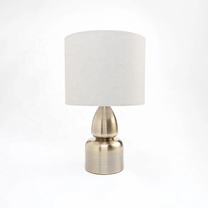 Aurora Sculpted Metal Table <b>Lamp</b> with Linen Drum Shade Antique Brass Finish Soft Ambient Lighting for Elegant Interiors - Product Image 2