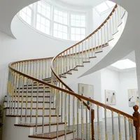 Rampe d'escalier incurvée moderne de luxe en acier inoxydable avec accents dorés, balustres résistants à l'eau pour une maison intérieure élégante