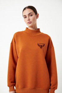 Hermosa mujer con una sudadera de cuello alto en un vibrante color rosa intenso, con delicado ribete de encaje y un audazco bordado de águila negra en el pecho. - Product Image 6