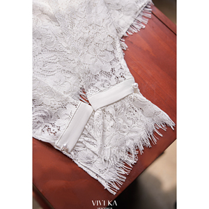 Blusa Corta de Verano Casual Blanca para Mujer con Encaje Floral, Cuello Simulado con Volantes, Manga Larga Acampanada y Dobladillo con Flecos, Diseño Personalizado ODM OEM SUNE - Product Image 6