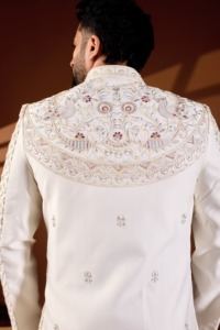 Costume de marié Vergo en soie, base perlée ivoire, style Sherwani, avec devant orné de motifs en losanges et de broderies Zardosi Paon, et détails en Cross Dori - Product Image 1
