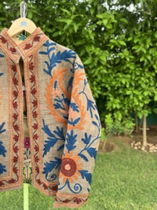 เสื้อแจ็คเก็ตบอมเบอร์ผ้าฝ้ายปักลายดอกไม้สีเบจสำหรับผู้หญิง แบรนด์ Handloom Haven งานแฮนด์เมด สไตล์โบฮีเมียน ลายชนเผ่า เหมาะสำหรับฤดูหนาวและฤดูร้อน - Product Image 3