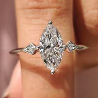 Magnifique bague de fiançailles à trois pierres de forme marquise avec une tige à bord coupé et des griffes de fixation sûres