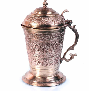 This antique, intricately carved <b>copper</b> jug features an ornate floral design and royal <b>handle</b>. Available at wholesale price. - Product Image 1