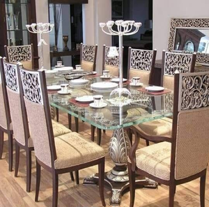 European glass top <b>dining</b> table set featuring silver ornate cut-out back <b>chairs</b> and pedestal base, available at wholesale prices - Product Image 1