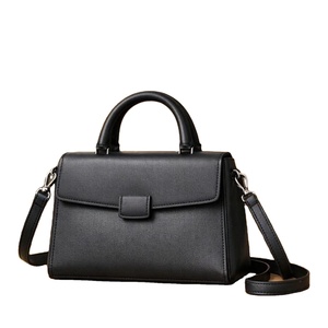 Bolso de mano negro estructurado con asa superior, diseñado como un accesorio versátil, adecuado para bolsos de cuero. - Product Image 1