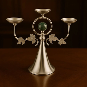 Candelabro plateado de tres brazos con detalles de hojas y una esfera central de mármol verde. Disponible a precios de mayorista. - Product Image 1