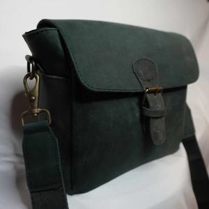 Sac bandoulière en tissu ciré vert foncé avec garniture en cuir véritable, fermeture à rabat et boucle, unisexe - Product Image 1