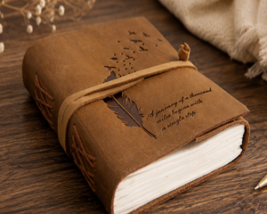 Carnet promotionnel en cuir à couverture rigide marron rétro, en papier de coton fait main sans acide, avec citation positive et motif plume d'oiseau en vol - Product Image 1