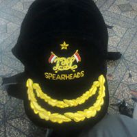 Esta es una gorra Kepi Civil W de cuero negro con insignia cruzada.