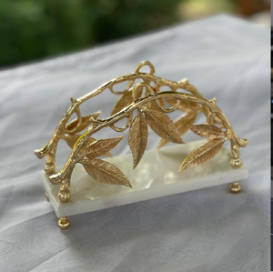 Un juego de servilleteros con un diseño único de hojas y ramas doradas sobre una base de mármol blanco de primera calidad. Disponible a precios de mayorista. - Product Image 1