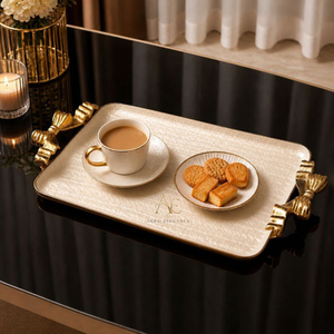 Elegante bandeja color marfil con asas doradas esculpidas en ambos lados, un accesorio de lujo sofisticado para una recepción refinada. - Product Image 1