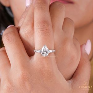 แหวนเพชรทรงลูกแพร์สามเม็ด ดีไซน์หรูหรา ประดับเพชรทรงบาแกตต์ด้านข้าง ตัวเรือนแบบปาเว่ พร้อมตัวล็อคแบบ V Prong ดีไซน์มินิมอล - Product Image 1