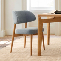 Chaise de salle à manger de style mid-century modern avec assise et dossier en lin rembourrés, pieds en bois massif