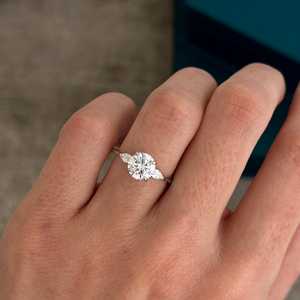 Bague à trois pierres en diamant de laboratoire rond et poire de 1,5 carat, or blanc 14 carats, pierres latérales en poire, certifiée IGI - Product Image 1