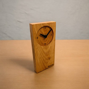 Reloj de mesa de madera que complementa plantas, libros y otros elementos decorativos. El reloj agrega un toque de lujo. - Product Image 1