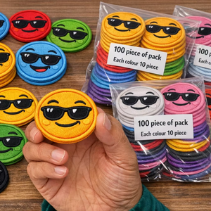 100 parches bordados surtidos con diseño de cara sonriente y cejas elevadas, 10 colores, termoadhesivos o para coser en ropa, bolsos y gorras - Product Image 1