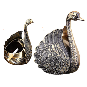Elegante cenicero de metal dorado con textura detallada de alas de cisne y soporte para cigarrillos, disponible a precios de mayorista. - Product Image 1