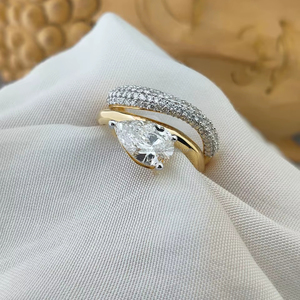 Anillo de diamantes con corte pera en oro amarillo, una combinación radiante de elegancia y brillo, con un resplandor dorado diseñado para cautivar cada momento. - Product Image 1