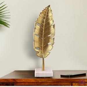 Hoja de monstera dorada detallada con recortes naturales sobre un pedestal de mármol premium. Disponible a precios de mayorista. - Product Image 1