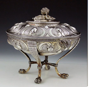 Sopera geométrica plateada con bordes de clave griega y asas con forma de cabeza de carnero. Tradiciones modernas disponibles a precios de mayorista. - Product Image 1