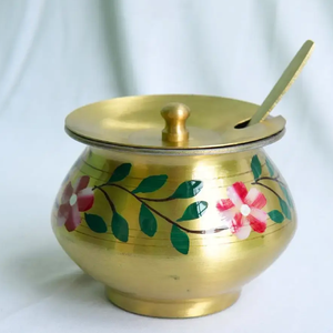 Lovely hand-painted brass ghee <b>pot</b> adorned with vibrant floral leaf motifs and a matching spoon. Available at wholesale price. - Product Image 1