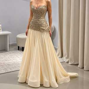 Robe de soirée longue coupe trapèze en sequins ivoire champagne, ornée d'un corset, décolleté cœur, jupe fluide en mousseline et nœud décoratif - Product Image 1